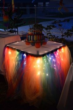 a table topped with a cake covered in colorful lights