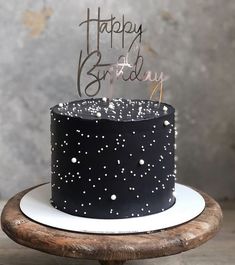 a black and white birthday cake sitting on top of a wooden table