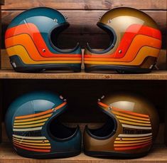 two helmets are sitting on top of each other in a wooden shelf next to another helmet