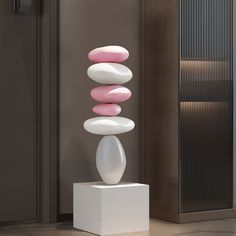 a white and pink sculpture sitting on top of a pedestal