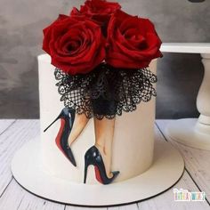 a white cake decorated with red roses and high heels