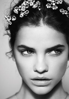 a woman wearing a tiara on top of her head with flowers in the hair