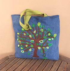 a bag with a tree painted on it sitting on a wooden bench next to a wall