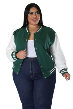 a woman wearing a green and white baseball jacket with stripes on the sleeves, standing in front of a white background