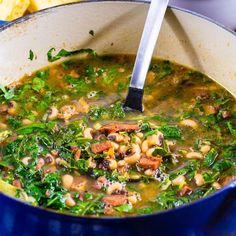 a blue pot filled with soup and vegetables