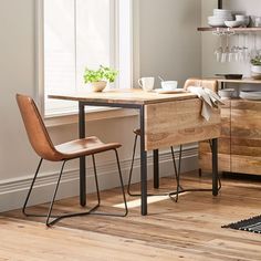 a table with two chairs next to it in front of a window