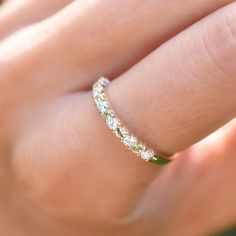 a woman's hand with a diamond ring on her left hand, showing the band