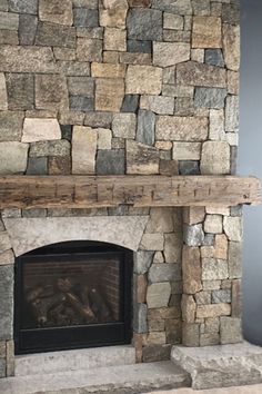 a stone fireplace in a living room with blue walls