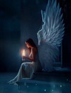 a woman sitting on the ground holding a lit candle in her hand and an angel wings above her head