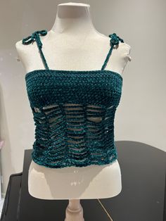 a mannequin wearing a green crochet top