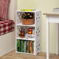 a white book shelf with books on it and a basket full of flowers in the corner