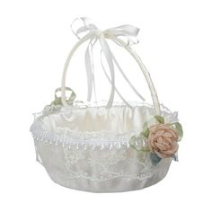 a white lace basket with flowers on the bottom and ribbon around the top, sitting on a white background