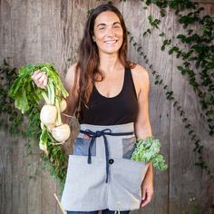 a woman is holding vegetables in her hands