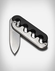 an open swiss army knife with black blades on the blade is shown in front of a white background