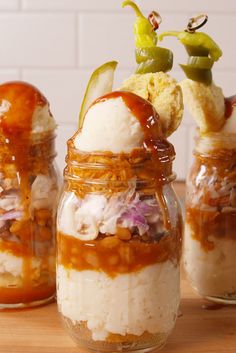 three jars filled with food sitting on top of a wooden table next to each other