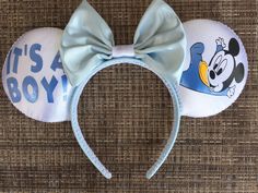 a mickey mouse headband with a blue bow on it's ears that says it's a boy