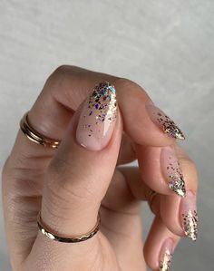 a woman's hand with pink and gold nail polish