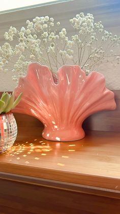 two vases with flowers in them sitting on a shelf