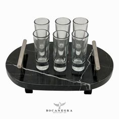 four glasses are sitting on a marble tray