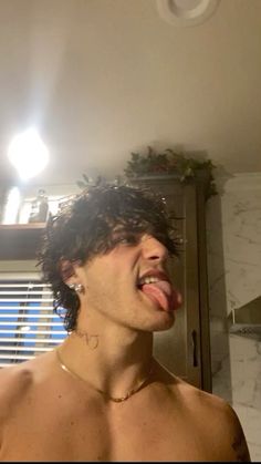 a shirtless man sticking his tongue out