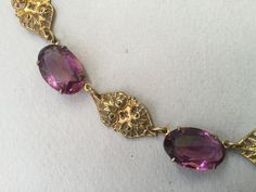 "Czech oval amethyst glass bezel/prong set cabochon collar. Wonderful Art Deco necklace that could have been made in the 20's or 30s. This is most likely made in the 1930s. Unusual bezels capture the colored glass gems that are in tandem with gilt brass filigree planks. Truly appealing necklace. This could be the antique necklace for you. Lovely condition but does show some slight greening on a couple of the gilt filigree pieces. Please look carefully. One of my favorites! 14 1/2\" long Glass an Victorian Jeweled Necklaces For Formal Occasions, Vintage Oval Jeweled Necklaces, Vintage Oval Jeweled Necklace, Vintage Jeweled Oval Necklace, Antique Oval Cabochon Gemstone Necklaces, Classic Oval Jeweled Necklaces, Vintage Oval Gemstone Necklace, Classic Oval Jeweled Necklace, Vintage Gemstone Necklace With Oval Cabochon