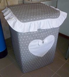 a grey and white storage box with polka dots on the bottom, ruffle trim around the top