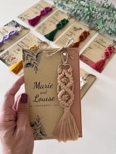 a hand holding a card with some tassels on it and the tag says marie and louise