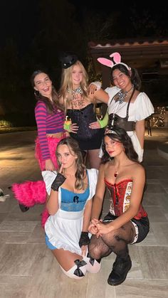 several women dressed up in costumes posing for a photo