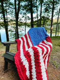 an american flag crocheted blanket on a park bench