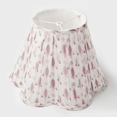 a lamp shade with pink and white designs on it