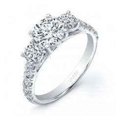 a three stone engagement ring with round diamonds on the band and side stones in white gold