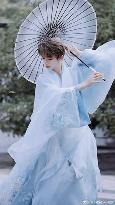 a woman in a blue dress holding an umbrella