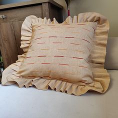 a close up of a pillow on a bed with a wooden headboard in the background