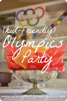 a vase filled with gummy bears sitting on top of a table next to a sign that says kid - friendly olympics party