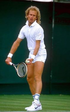 a man holding a tennis racquet on top of a tennis court with a ball in his hand