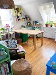 a living room filled with lots of furniture and bookshelves on top of hard wood floors