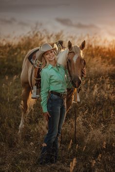 a woman standing next to a horse in a field