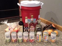 an assortment of liquors and condiments sitting on the counter in front of a red ice bucket