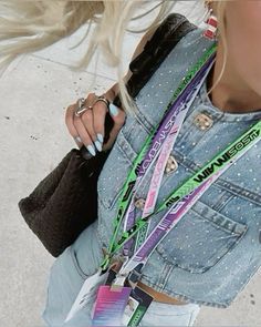 a woman with blonde hair wearing a jean jacket and bracelets