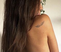 the back of a woman's shoulder with leaves on it