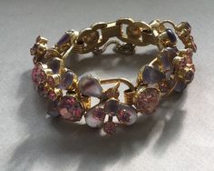 "Delizza and Elster, Juliana design with pink rhinestones and givre lavender satin glass teardrop accents. Beautiful, sparkling diamond like gems on this lovely link bracelet with a gold finish. A larger pink chaton is on a link that links two other ornate gem clusters. A total of five clusters and six large gem connectors. There is a chain guard as well as the very secure clasp. Wear this lovely bracelet on your fanciest outing. Quite a stunning and rare Juliana by Deliza and Elster from their Pink Crystal Bracelet For Formal Occasions, Pink Crystal Bracelets For Formal Occasions, Formal Pink Crystal Bracelet, Elegant Purple Crystal Bracelet For Party, Elegant Pink Bling Bracelets, Elegant Pink Jeweled Bracelets, Elegant Purple Jewelry With Bling, Jeweled Crystal Bracelet For Wedding, Costume Jewelry Jeweled Crystal Bracelet For Wedding