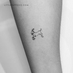 a small black and white dog tattoo on the left inner arm by littlelitatoos com