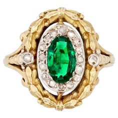 Ring in 18 karat yellow gold, eagle head hallmark. Magnificent antique ring, its oval mounting is formed of a laurel wreath engraved in the gold retained by a ring lily flower on its departure, and decorated with a pearl in fall. In the center of this decoration, an oval pattern is adorned with a faceted emerald surrounded by rose-cut diamonds. On either side, 2 rose-cut diamonds are set on the start of the ring. The ring is numbered inside 6578. Weight of the emerald : 0.70 carat approximately. Tree Jewelry, Gold Eagle, Antique Ring, Etsy Gold Ring, Eagle Head, Laurel Wreath, Jewelry Tree, Yellow Gold Ring, Lily Flower