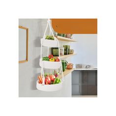 three hanging baskets filled with fruits and vegetables on a wall in a kitchen, next to a sink