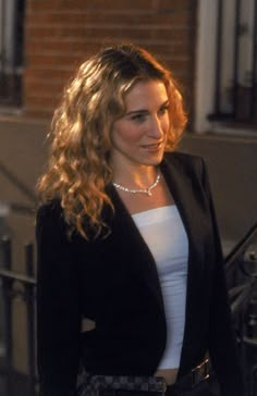 a woman wearing a black jacket and white top