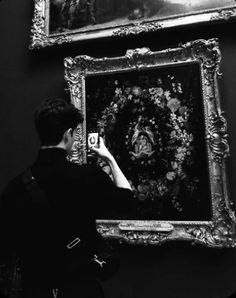 a person taking a picture of a painting