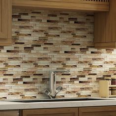 a kitchen with wooden cabinets and tile backsplashes on the countertop, along with a stainless steel faucet