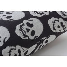 a black and white pillow with skulls on it