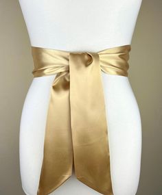 "Pale Gold Satin Sash, Light Gold Sash Belt  Wide Gold Wedding Dress Sash  Gold Bridal Sash Belt  Pale Gold Bridesmaid Sash  Satin Swank  This Satin Swank® reversible waist sash is the perfect finishing touch for your bridesmaid, wedding, or special occasion dress, or just the right piece to add instant polish to your dress or top. Depending on your waist size and the length you choose (60, 75, and 90 inch lengths available), you can wrap the sash around your waist once or twice. You decide whether to tie the sash in a bow or a simple knot with long-hanging tails. Tie in front, in back, or on the side. Luxury charmeuse satin fabric in luminous pale gold on both sides means there is no wrong side of the sash peeking through, resulting in the perfect finishing touch for your special occasion Luxury Elegant Sashes, Wedding Sash With Tie Back, Elegant Satin Sash With Tie Back, Satin Sash With Bow For Bridesmaids, Satin Bridal Belt For Bridesmaids, Wedding Satin Tie Back Sash, Satin Bridal Belt For Party, Bridesmaid Sash With Satin Bow, Bridesmaid Satin Sash With Satin Bow