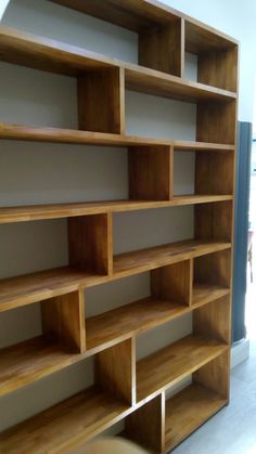 an empty wooden book shelf in the corner of a room